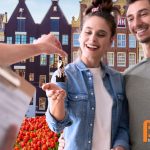 Jong stel ontvangt de sleutel van hun nieuwe huis in een Nederlandse nieuwbouwwijk, gefinancierd met de overwaarde van het huis van hun ouders.