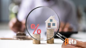 Illustratie van een vergrootglas met daarin een procentteken en een huis, symboliserend de hypotheekrente en woningfinanciering in 2025.